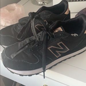 Black and gold New Balance sneakers,.